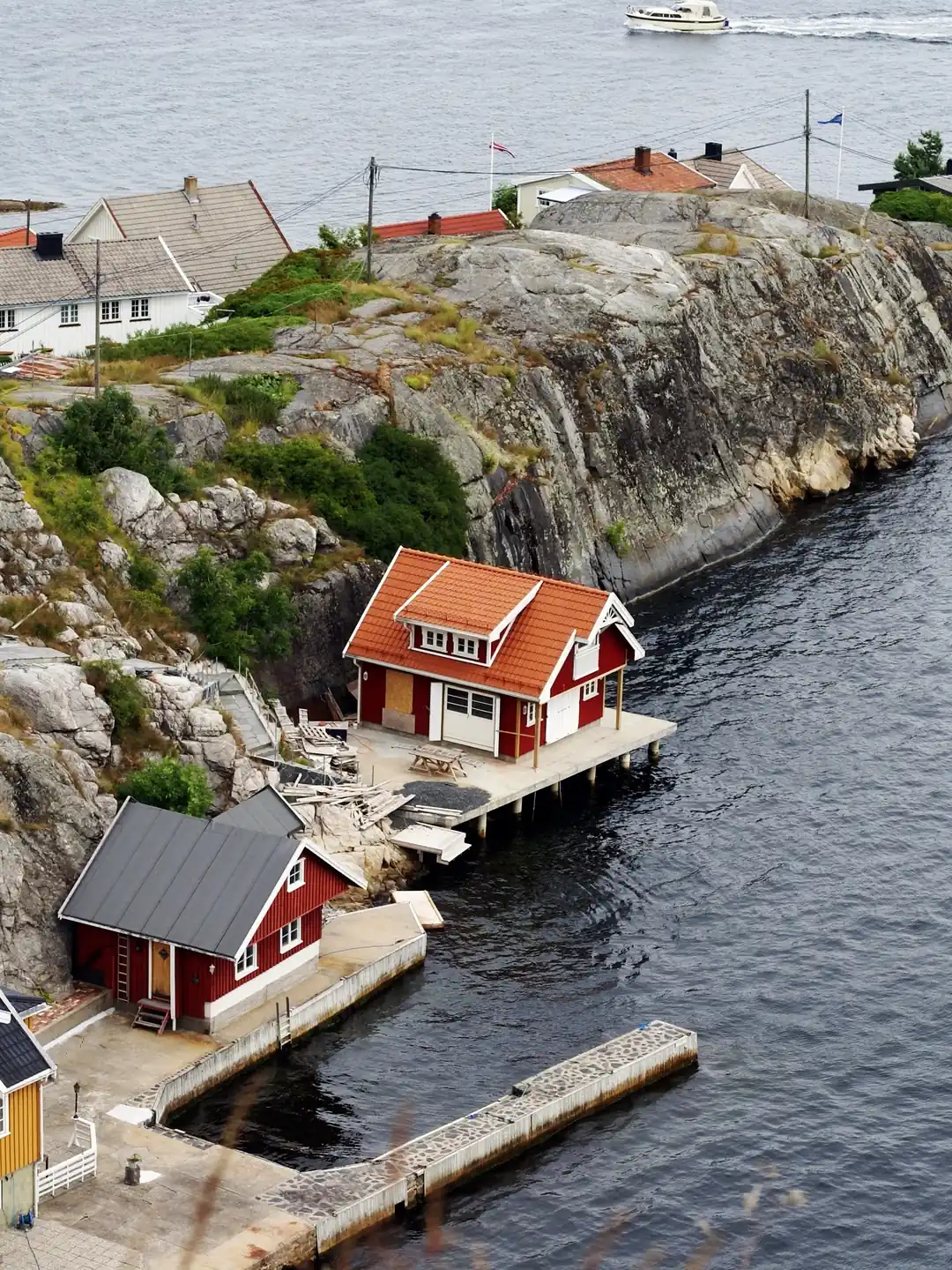 Small red houses and a jetty on the rocky coast at Kragerø, Telemark, Norway