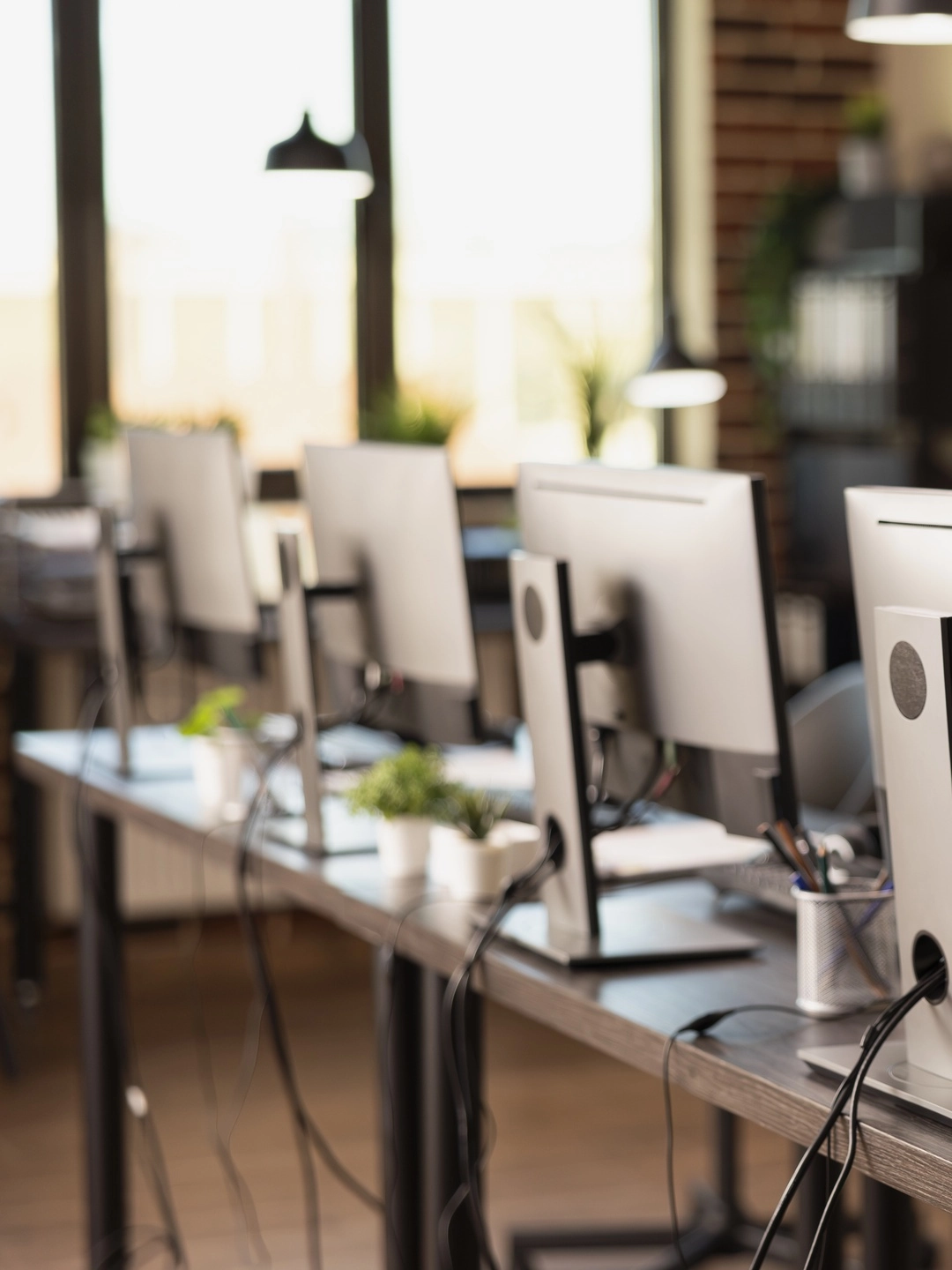 A row of workstations along one long desk in a software company office
